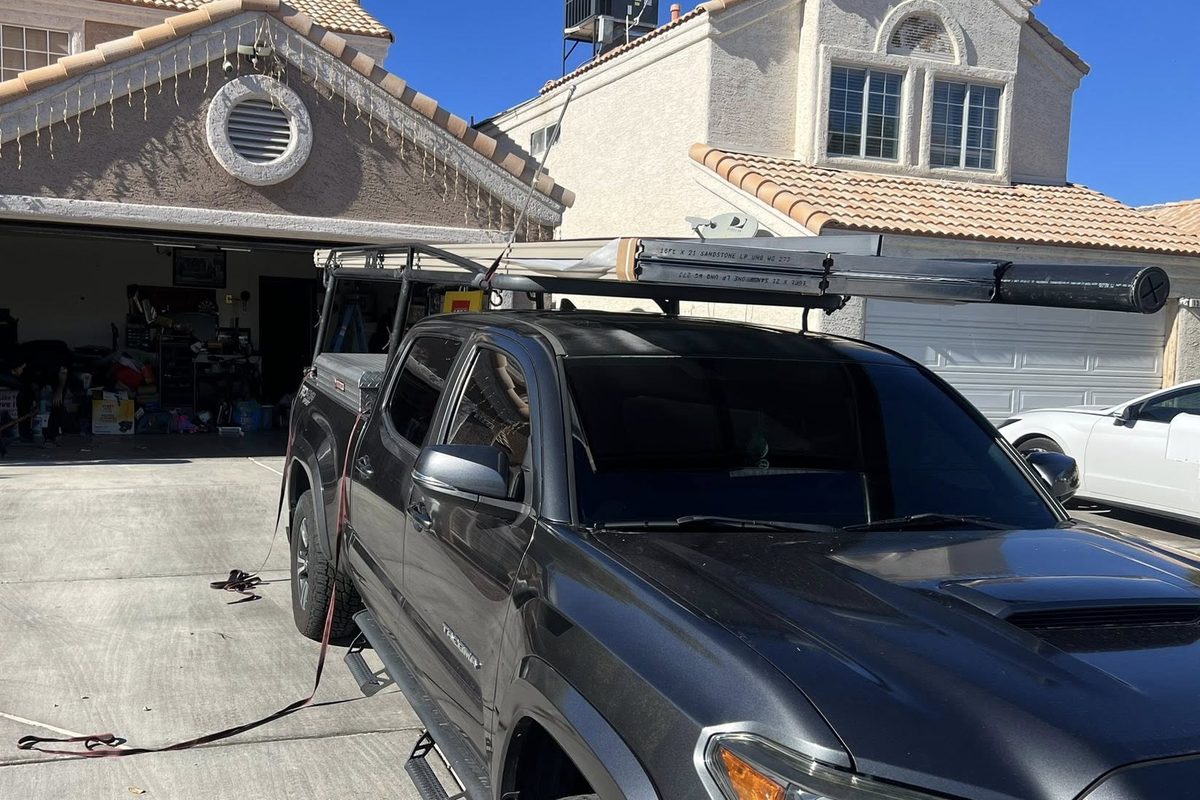 Angels Garage Doors work truck in a Las Vegas driveway, ladder rack loaded, with the garage door open during a job